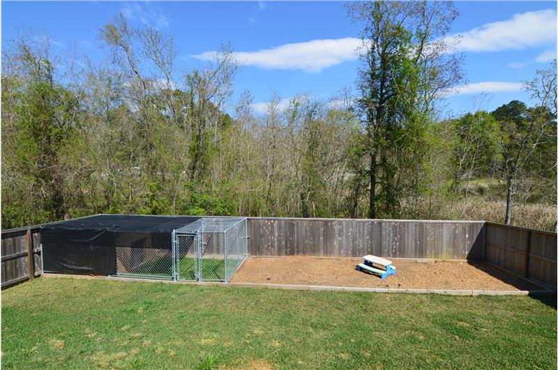 Large back yard with a dog run and a muclhed kids play area.
