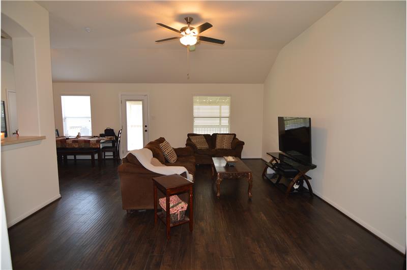 Open concept family room with wood laminate plank flooring.