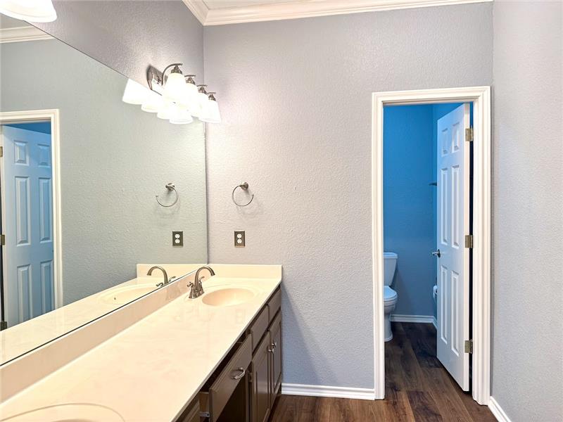 Primary bathroom features double vanity, walk in remodeled shower