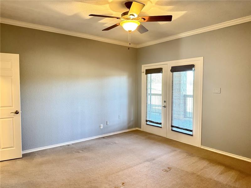 Primary bedroom has French doors leading to oversized back patio with golf course views