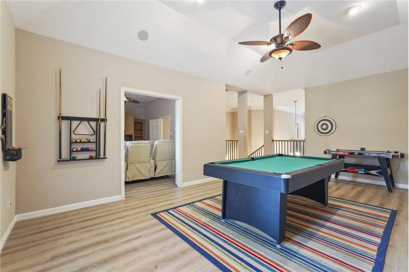 Game room upstairs with a built-in bar area equipped with a microwave and mini-fridge. French doors provide leading you to the b
