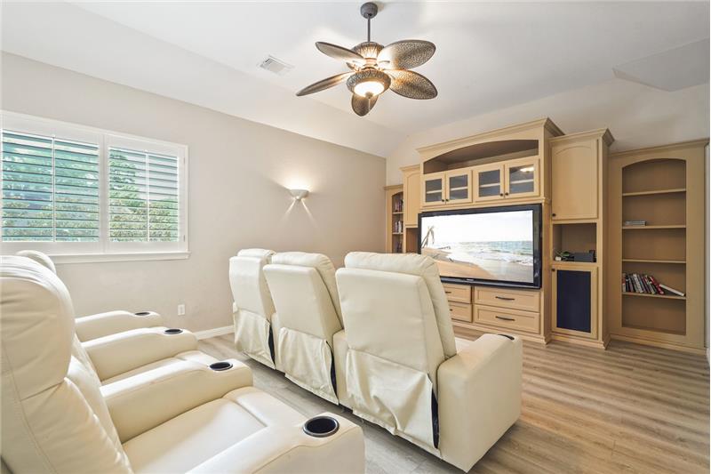 Cozy home theater room with comfortable recliners that are staying with the house, a large built-in entertainment center. Enter 