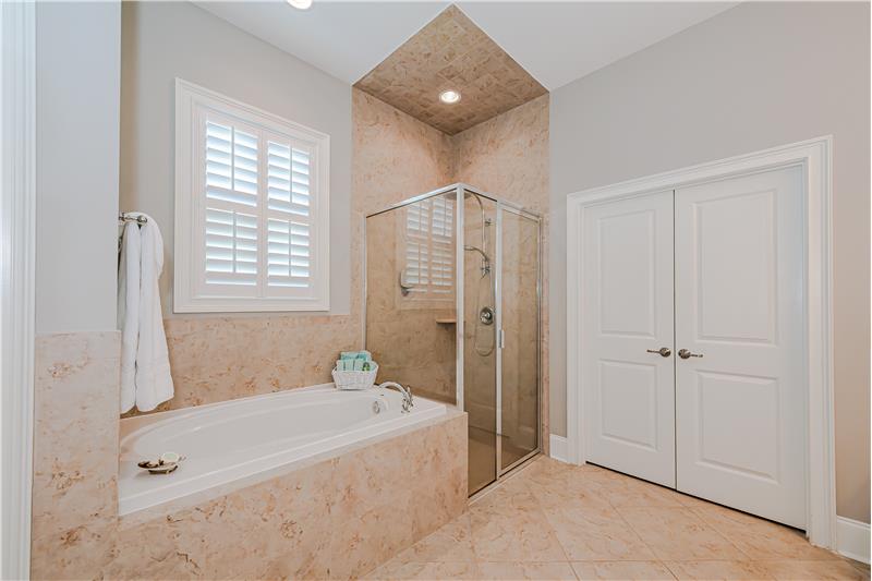 Tile surround, tile floors, walk-in closet. Window over the soaking tub provides natural light.