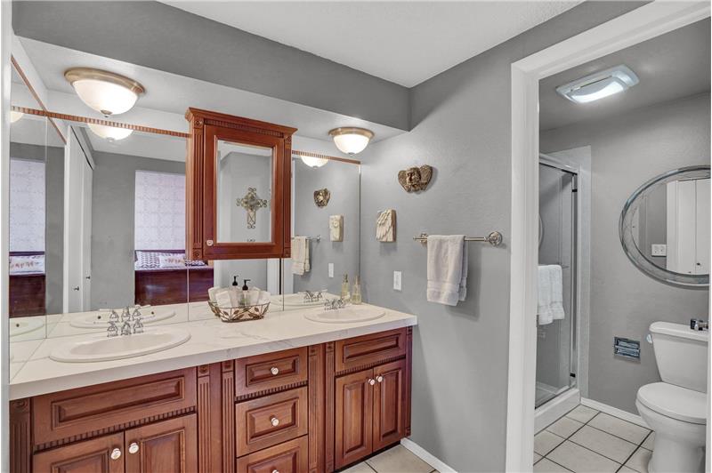 The Primary Bathroom features a dual sink vanity, medicine cabinet, and tiled tub/shower