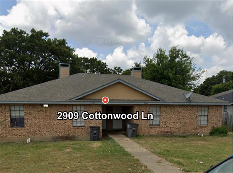 View of front of house featuring a front yard, a chimney, and brick siding
