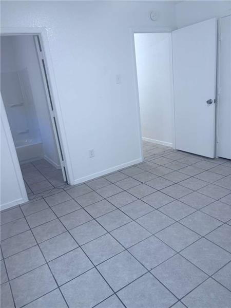 Unfurnished bedroom featuring light tile patterned floors and a closet
