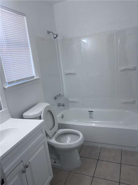 Full bath with tub / shower combination, light tile patterned floors, and vanity