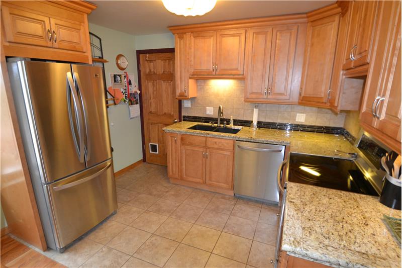 Updated kitchen with tile floor & backsplash and granite counter with Silestone sink - stainless appliances included