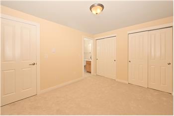 Primary bedroom with 2 sets of closets and direct entrance to en suite bathroom.