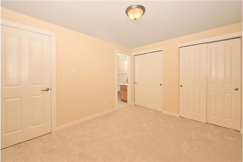 Primary bedroom with 2 sets of closets and direct entrance to en suite bathroom.