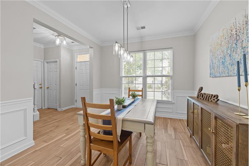 Dining room overlooks entrance, features generous millwork, new light fixture