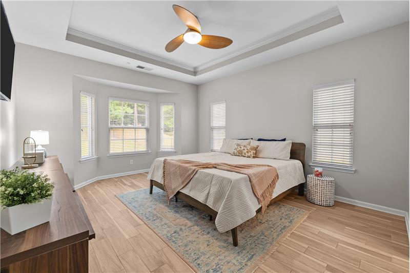 Main floor primary suite with trey ceiling, bay window with room for sitting area