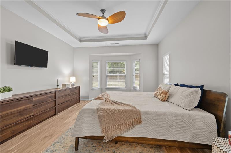 Primary suite offers ample space for king size bed, larger furniture pieces for comfort without compromise