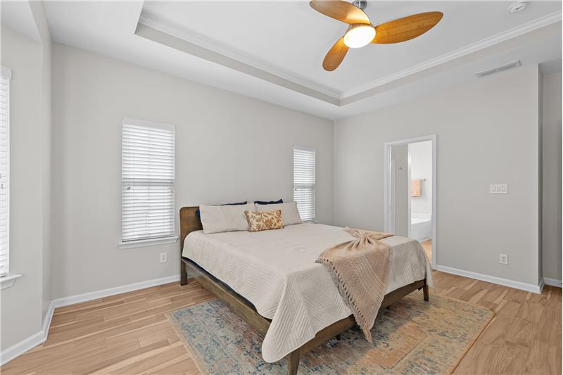Windows on two sides of the just painted primary bedroom provide great natural light