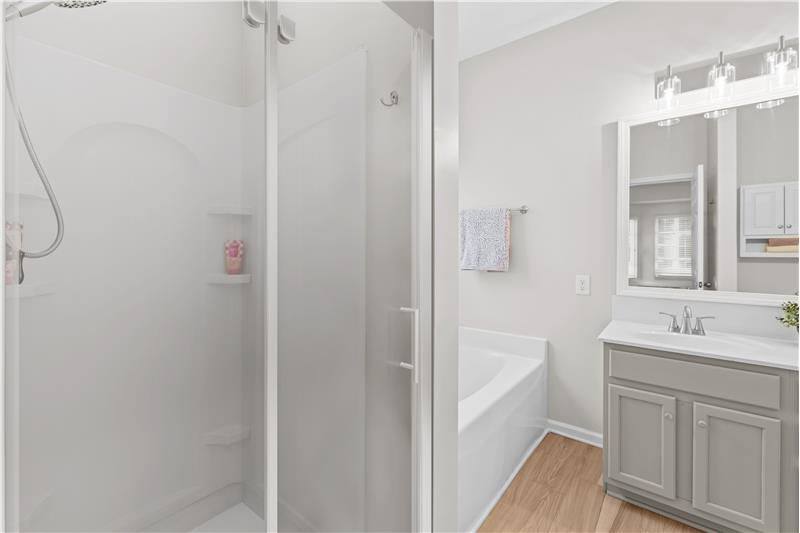 Step-in shower with new glass door in primary bathroom