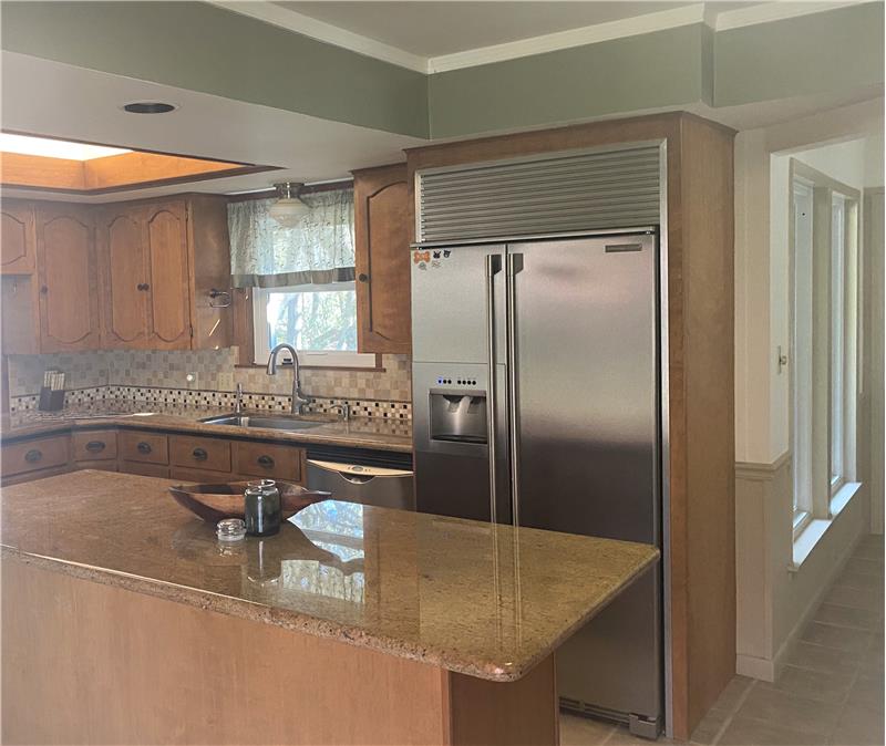 Kitchen has beautiful cabinets and counter tops and stainless appliances
