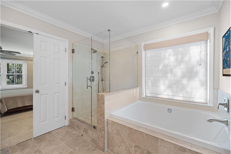 Large frameless shower, deep soaking tub, tile floors and surround
