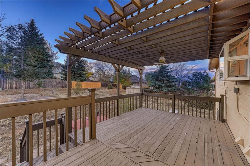 Covered deck overlooking the fenced backyard