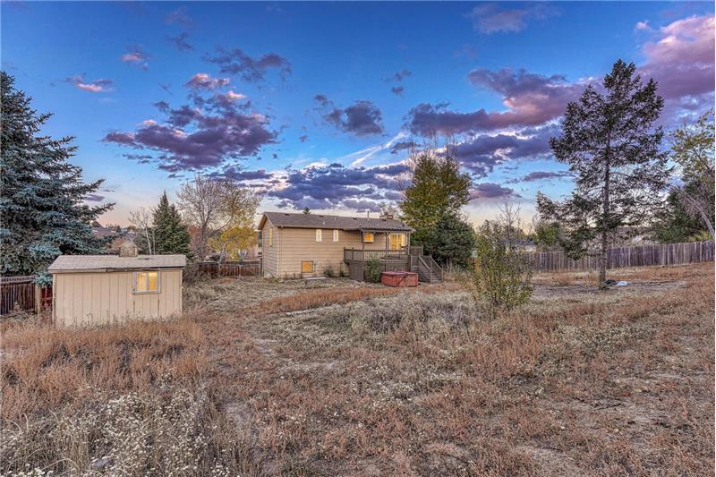 Sunset views of the backyard that includes a storage shed for tools & toys