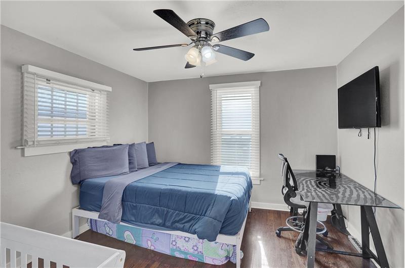 Upper level Bedroom #3 with lighted ceiling fan and mounted television that stays