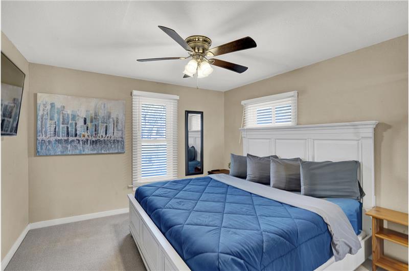 Upper level Primary Bedroom has neutral carpet and lighted ceiling fan