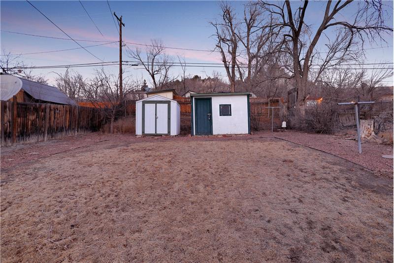 Two storage sheds in the fenced backyard for tools and toys