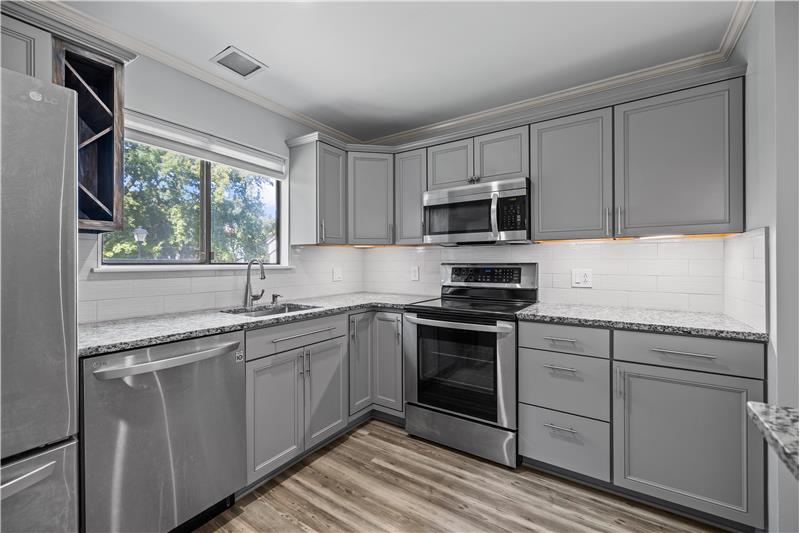 Grey cabinets, granite counters, tile backsplash