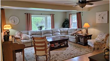 Inviting living room with  several windows to bring in the natural light.