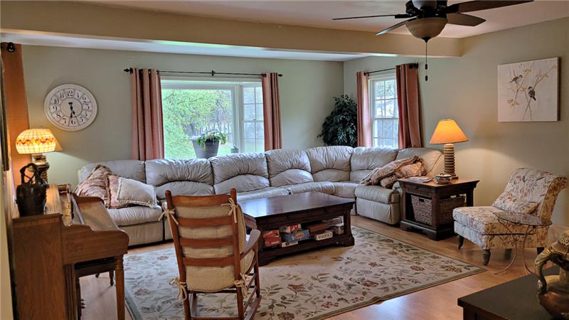 Inviting living room with  several windows to bring in the natural light.