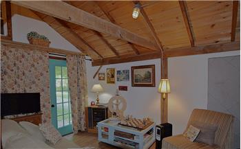 Spacious room featuring exposed wood ceiling beams, wood-finish