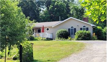 Exterior featuring horizontal siding, a white railing, an arched entry door,  and new roof.