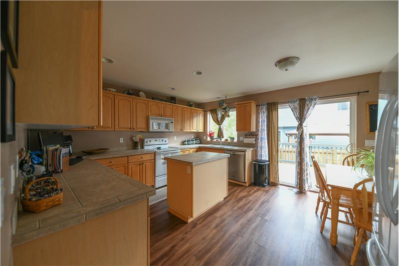Large eat-in country kitchen with island and wood cabinets.