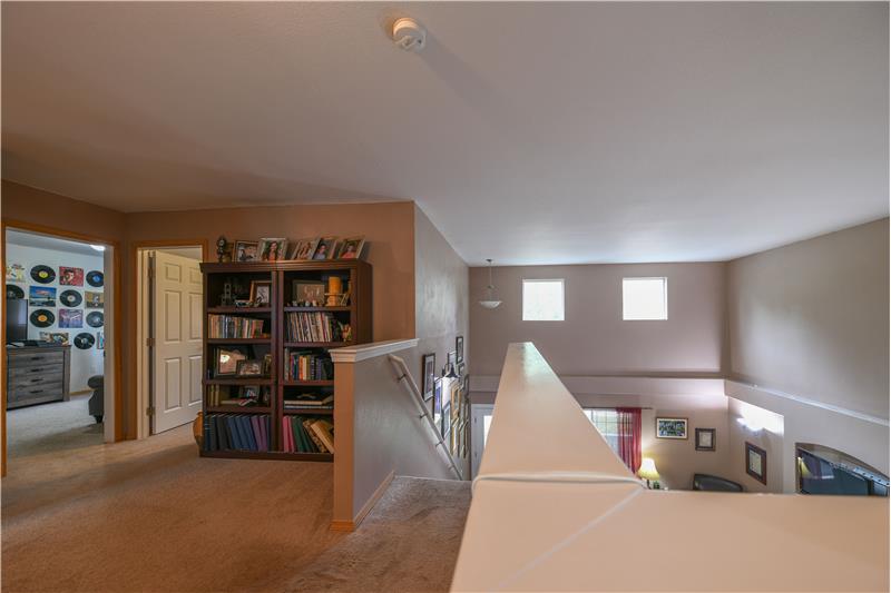 Upstairs looking at the loft and towards the cathedral ceiling to the living room. Wonderful transom windows!