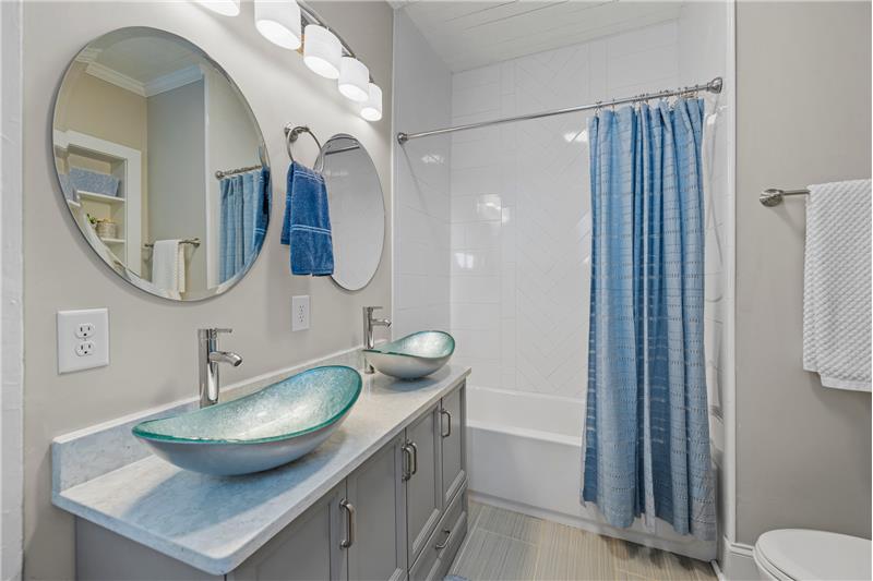 Owner's bathroom with custom tile finishes, quartz counter, designer glass vessel sinks