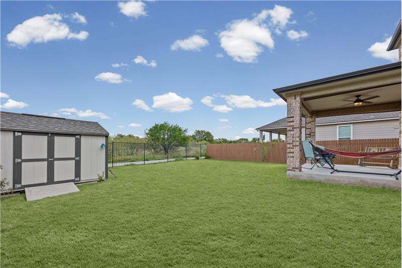 Corner lot backs up to greenbelt. Home has a covered back porch with ceiling fan. 
Storage shed with shelves and ramp.