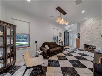 Living room or Dining room with an inviting chandelier, ornamental molding, and a see through fireplace.