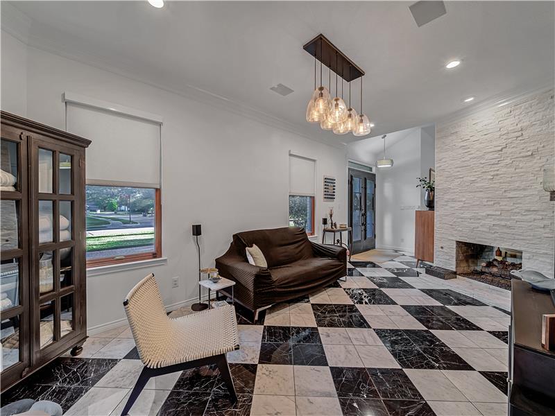 Living room or Dining room with an inviting chandelier, ornamental molding, and a see through fireplace.