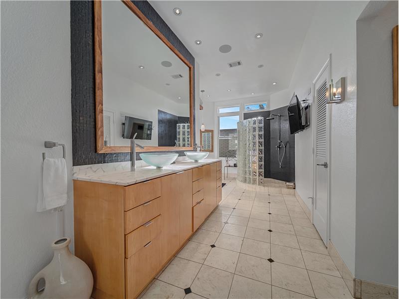 Primary Bathroom featuring a double vanity, decorative mirror and luxury tile patterned floors!