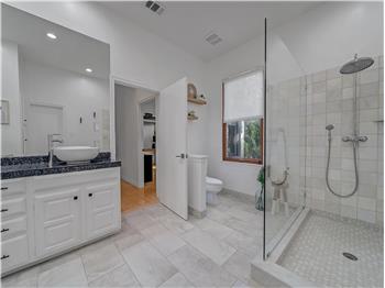 Bathroom featuring tile patterned flooring, vanity, and an enclosed shower