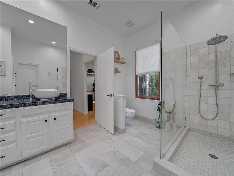 Bathroom featuring tile patterned flooring, vanity, and an enclosed shower