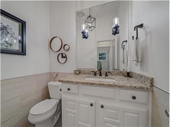 Half Bathroom featuring tile walls, vanity, and toilet