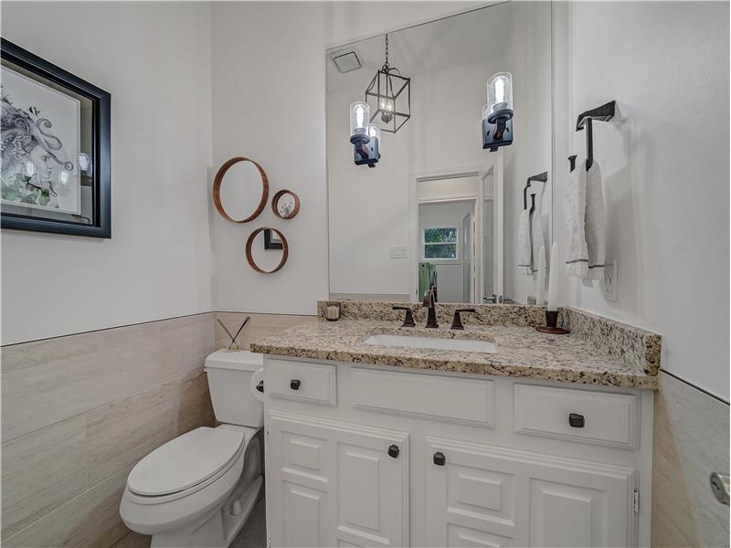 Half Bathroom featuring tile walls, vanity, and toilet