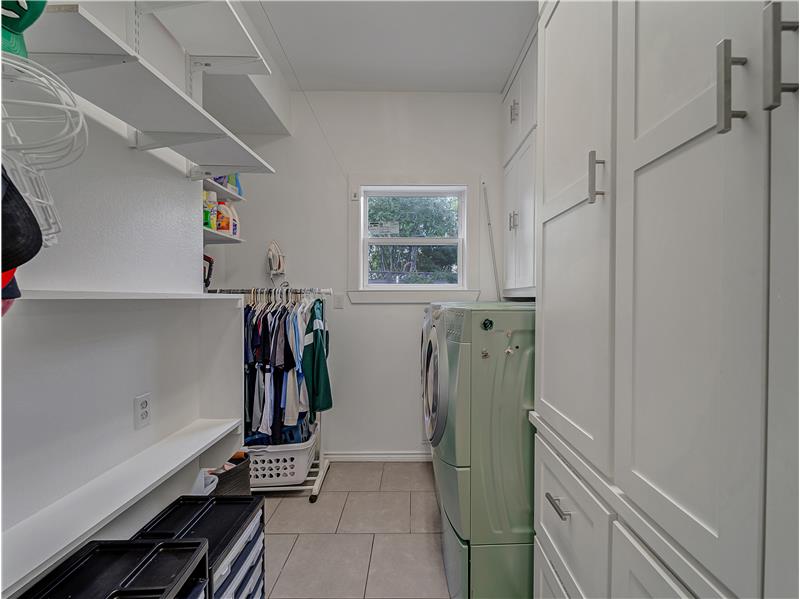 Huge laundry room with cabinets, washing machine and clothes dryer, and light tile patterned floors