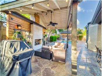 View of patio featuring ceiling fan and an outdoor living space with a fireplace