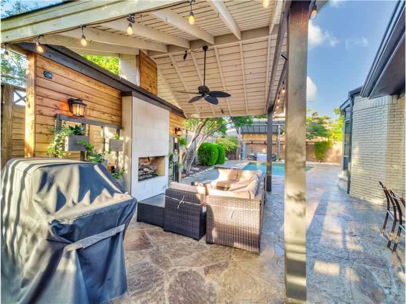 View of patio featuring ceiling fan and an outdoor living space with a fireplace