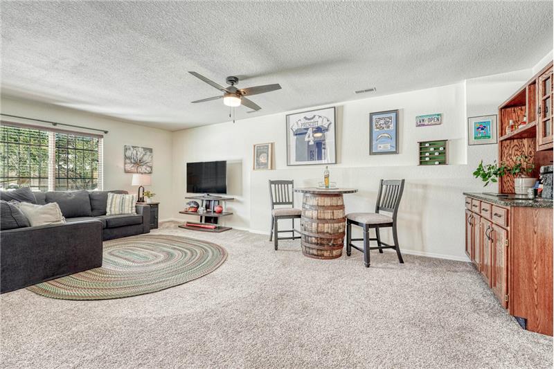 Large Rec Room in Basement with Ceiling Fan and Wet Bar