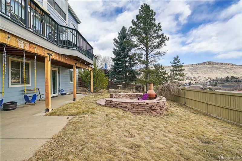Backyard showing patio and full-width main-floor deck