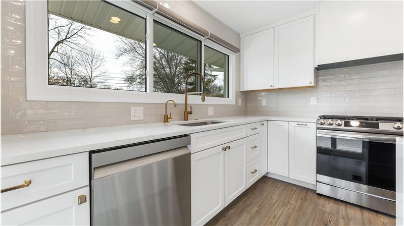 Deep stainless sink with instant hot water dispenser. Tile backsplash
