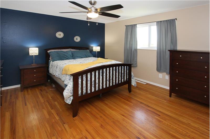 Master bedroom with hardwood flooring and ceiling fan