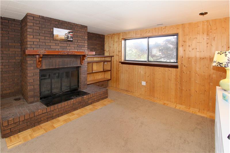 Lower level family room offers a wood burning fireplace